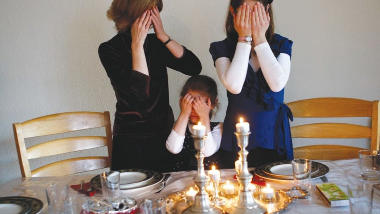 Family lighting Shabbat candles together